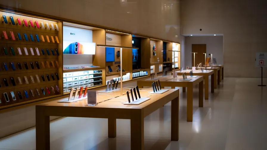 Butik med borde og vægreoler fyldt med udstillede smartphones